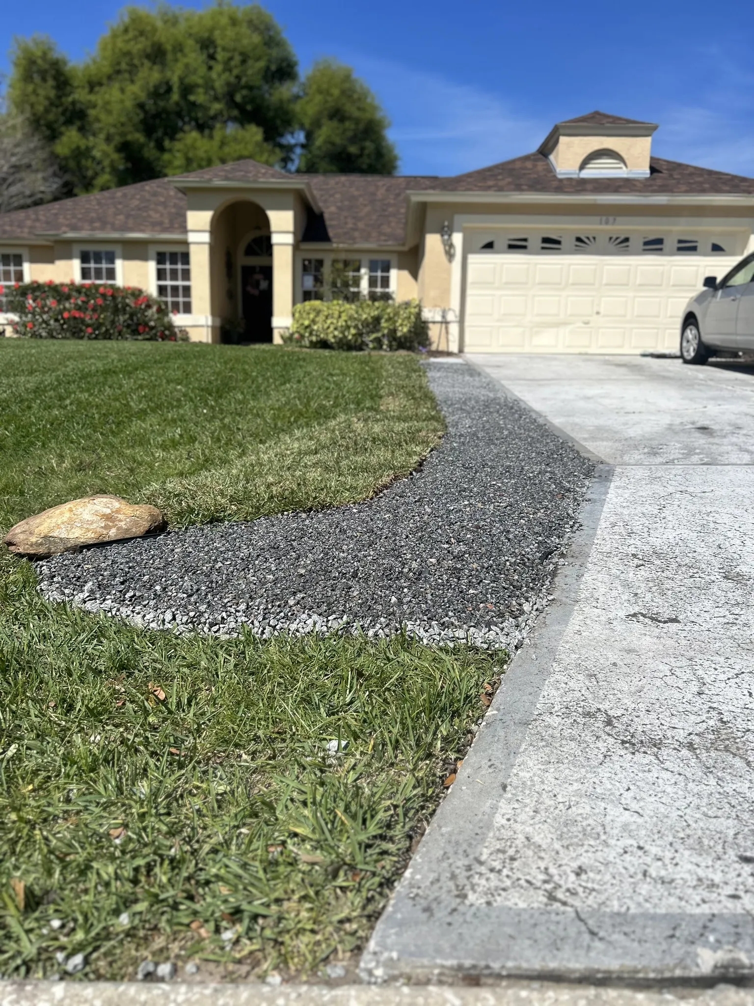 A professional installs a sprinkler system in the front yard of a house.