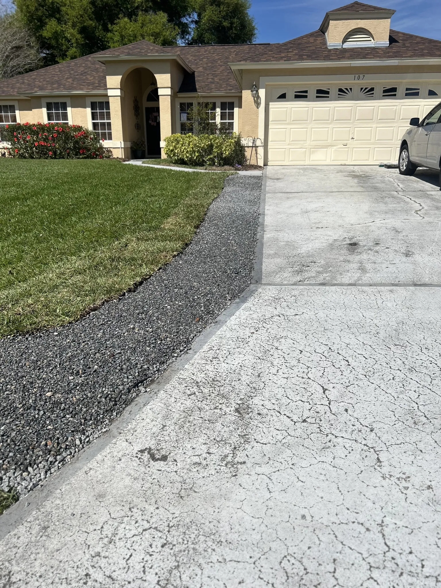 A residential home with a newly installed sprinkler system and landscape lighting along the driveway.